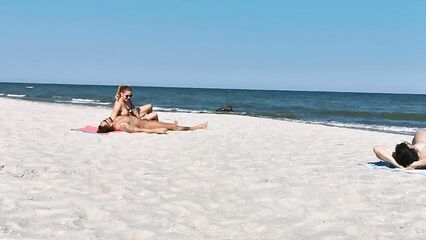 Два парня и девушка устроили групповой секс на нудистском пляже